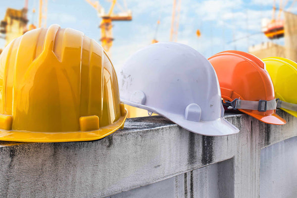 hard hats balancing on a fence