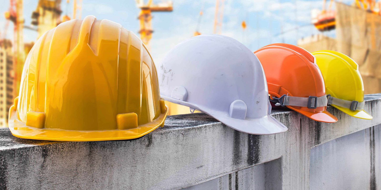 hard hats balancing on a fence