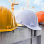 hard hats balancing on a fence