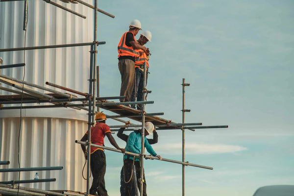 a team of workers on a construction site scaffolding