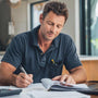radie business owner reviewing year-end business paperwork with Construction Diary, calculator, and financial documents for tax planning