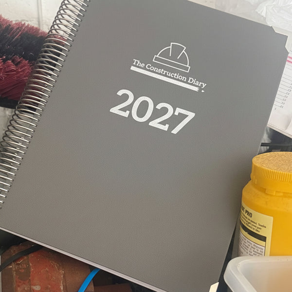 Gray notebook titled 'The Construction Diary' with '2027' on a messy background